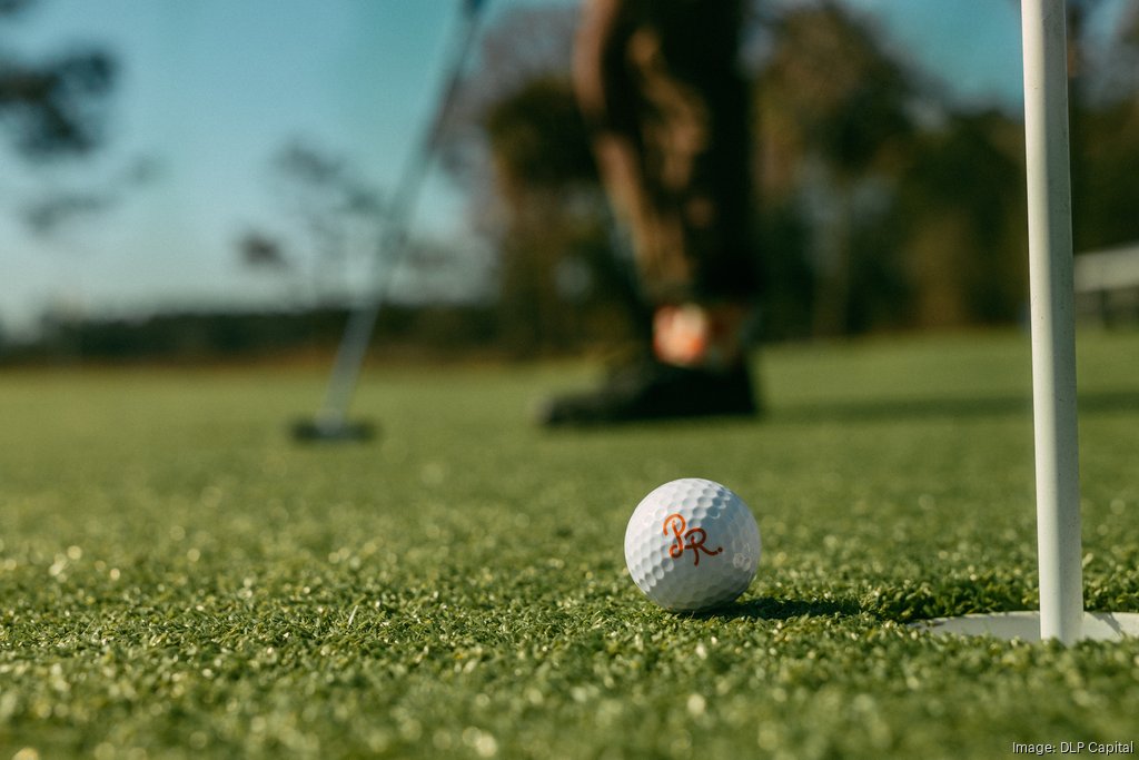 A branded Pine Royal golf ball resting on a putting green
